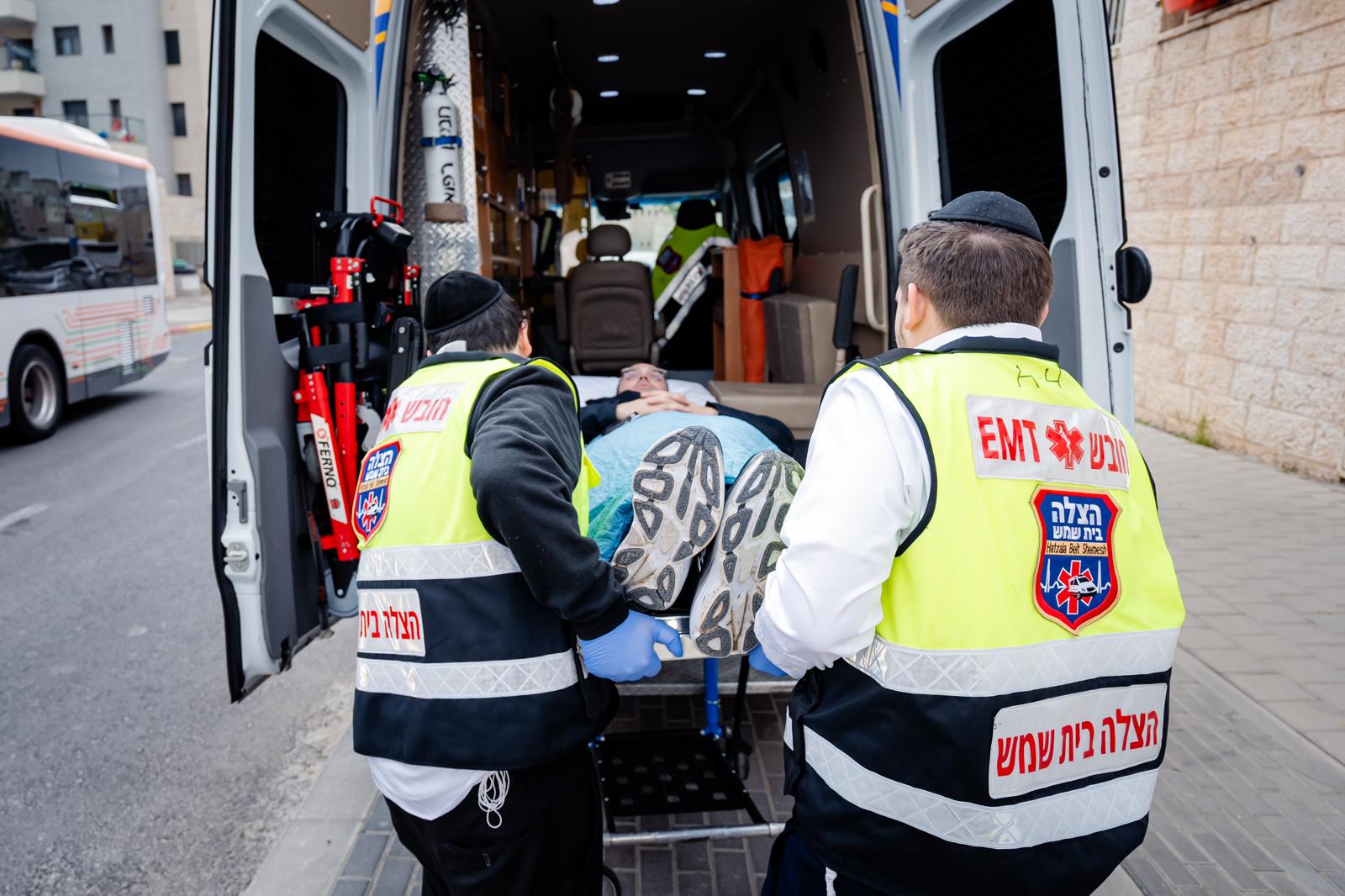 Two HatzBS volunteers loading a patient into an ambulance